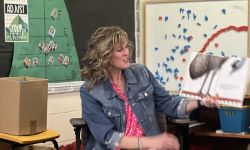 Christine Beachler holds up a book while reading it. 