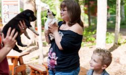 People smile as they hold puppies