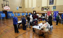People voting in a school gym.