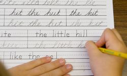A child practicing cursive. 