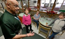 Cam McClure, wearing a green polo, talks to volunteers at the Waterford Senior Center.