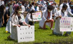 people in white coats kneeling 