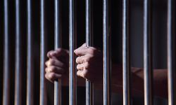A prisoner gripping prison bars