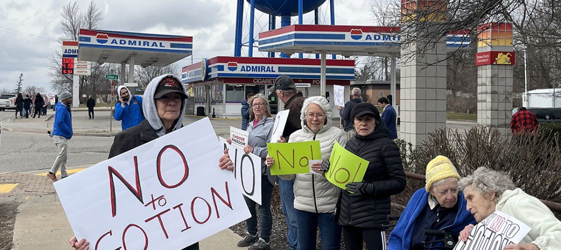 Marianne Pitts, center in white jacket, joined several hundred people in Big Rapids in 2023, lining both sides of South State Street to protest Gotion.